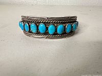 Front view of cuff showing ten turquoise stones and decorative silverwork