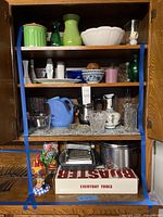 Overall view of four cabinet shelves and contents
