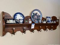Full view of 54" wooden coat rack with china pieces arranged on shelf