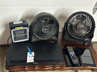 Front view of Blu-ray player, fans, heater, remote, tablets