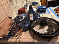 Group view showing Le Creuset pieces, tagine, pig dish, grill