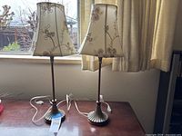 Pair of matching table lamps with shades displayed on table