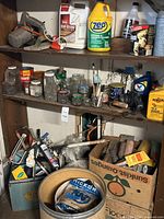 Overview of three shelves with cleaners, jars of fasteners, box of hand tools