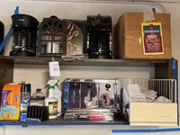 Two coffee makers, lantern, boxed pasta maker, upper shelf