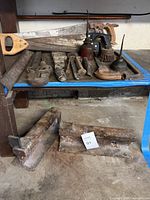 All tools on shelf including saws, wrenches, clamps, oil cans, files and brackets