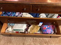 Two open dresser drawers showing multiple fleece and flannel garments