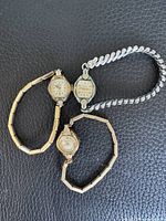 All three vintage women’s wristwatches on black background