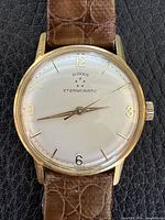 Front view showing dial, hands, numerals, bezel, strap
