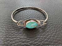 Front view of sterling silver bangle with turquoise cabochon