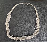 Full view of braided sterling necklace on black background