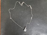 Full necklace laid flat showing chain, pendant, and extension links