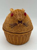 Front view of wicker rabbit head basket with lid and red button eyes