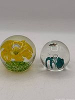 Front view of both paperweights showing floral designs