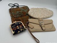 All four purses: Coach wristlet, tapestry pouch, beaded clutch, floral frame coin purse