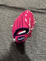 Side view of Rawlings pink and purple youth glove showing brand patch and lacing