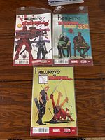 Front covers of three bagged Hawkeye vs Deadpool comic books issues 001-003