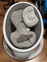 Full view of Munchkin baby swing with seat insert and headrest