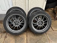 Four Konig rims with Michelin tires leaning against wall