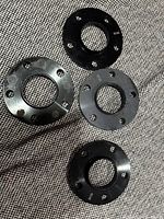 Top view of four wheel spacers showing bolt holes and engravings