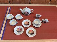 Full 11-piece tea set laid out with ruler for scale