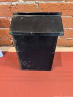 Front view of mailbox showing black finish and rectangular form