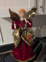 Front view of angel tree topper showing gown, wings and candle lights