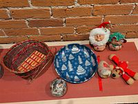 All items grouped: wicker sleigh basket, blue tray, Santa & Mrs. Claus plush, red felt reindeer, egg and ball ornaments