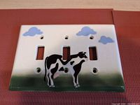 Front view showing cow design, three toggle openings and cloud motif