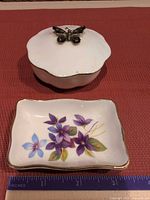 Top view dish with floral design and covered box showing butterfly finial