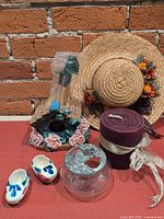 Group shot of all items: birdhouse, jar, clogs, candle, tools, straw hat