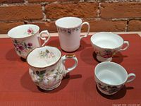 Five assorted floral teacups displayed
