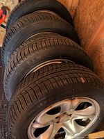 Stack of four Michelin winter tires mounted on steel rims
