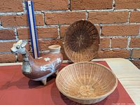 Terracotta llama vessel and two baskets arranged together