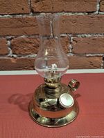 Front view showing brass body, glass chimney, wick mechanism