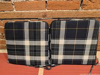 Front view of both plaid cushions side by side showing pattern and ties