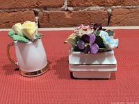 Both bone china miniatures side by side on red surface