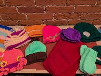 Full group showing hats, scarves and mittens on tabletop