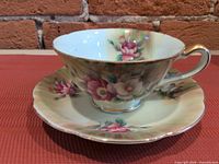Teacup on saucer, showing floral design and gold trim