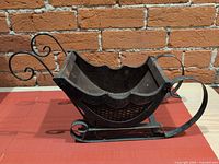 Side view showing wood body, metal runners, scroll handle