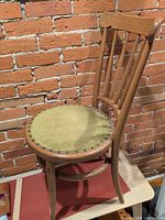 Full view of wooden spindle-back chair against brick wall