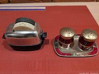 Overview of toaster shaker set beside tray with red shakers