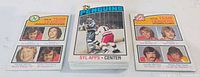 Stack of 1976-77 O-Pee-Chee hockey cards flanked by two team leader cards