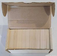 Open cardboard box showing top edges of large stack of trading cards