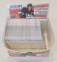 Open cardboard display box showing spine edges of stacked trading cards