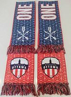 Full view of both sides of the dual-sided Atlético Ottawa supporters scarf showing ONE text, team crest, patterns and fringe