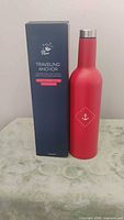 Red stainless steel wine tumbler next to original navy box