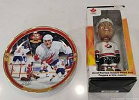 Plate and boxed bobblehead side by side