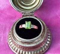 Ring front view showing peridot and diamonds in case