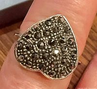 Heart-shaped marcasite ring on finger, close view of stone setting
