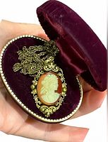 Front view of cameo pendant and chain in velvet box